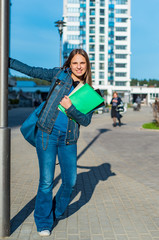 Obraz premium Back to school student teenager girl holding books and note books wearing backpack. Outdoor portrait of young teenager brunette girl with long hair. girl on city
