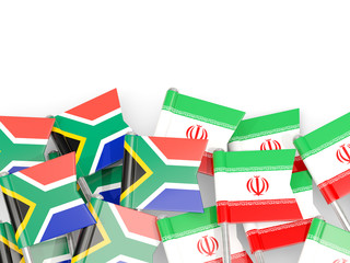 Pins with flags of South Africa and iran isolated on white.
