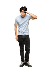 Naklejka premium A full-length shot of a Asian man with blue shirt looking far away with hand to look something over isolated white background