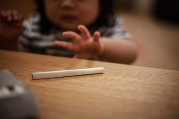 煙草に手を伸ばす赤ちゃん