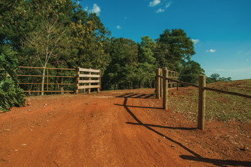 Farm gate with cattle guard and barbed wire fence