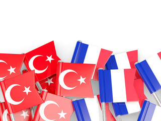 Pins with flags of Turkey and france isolated on white.