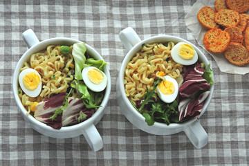 Two bowls of noodles, salad mix and quail eggs. Healthy lunch. Keto diet.