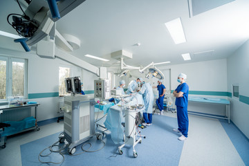 Spinal surgery. Group of surgeons in operating room with surgery equipment. Laminectomy