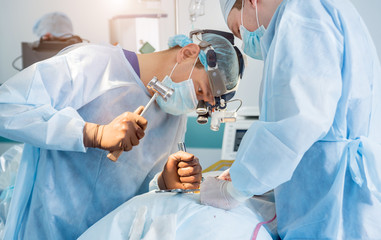 Spinal surgery. Group of surgeons in operating room with surgery equipment. Laminectomy