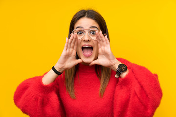 Young woman over isolated yellow wall shouting with mouth wide open