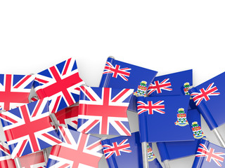 Pins with flags of UK and cayman islands isolated on white.