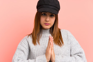 Fashion woman with hat over pink wall pleading