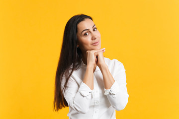 Portrait of stunning pretty young woman in white shirt put hand prop up on chin looking camera isolated on bright yellow orange wall background in studio. People lifestyle concept. Mock up copy space.