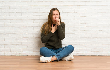 Fototapeta na wymiar Young woman sitting on the floor is suffering with cough and feeling bad