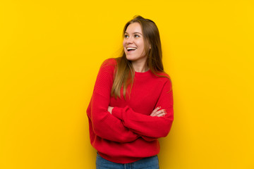 Young woman over yellow wall happy and smiling