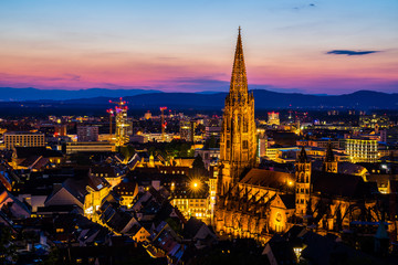 Germany, Red sky over romantic lights of city freiburg im breisgau and minster church