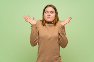 Young woman with turtleneck sweater making doubts gesture