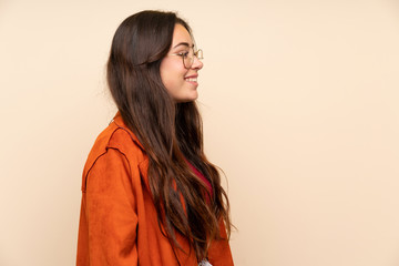 Teenager girl with coat standing and looking to the side