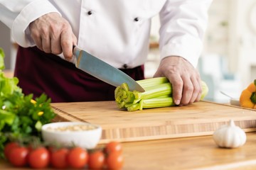 Chef cutting fresh and delicious vegetables for cooking.