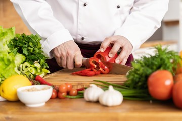 Chef cutting fresh and delicious vegetables for cooking.