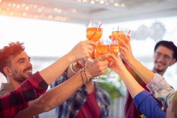 Group of young happy people toasting with glasses of spritz (cocktails) - rooftop birthday party...