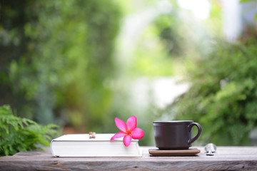 Black coffee cup with small flower  and notebooks 