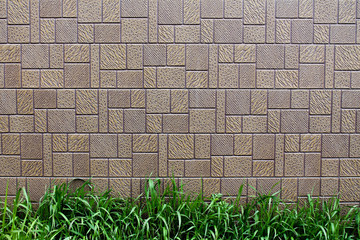 Brown brick wall with grass at the bottom background, wall backdrop