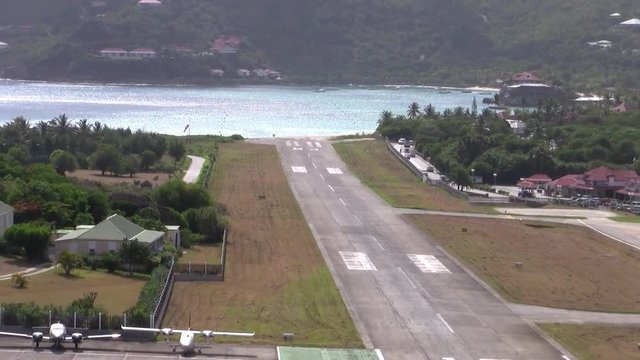 Zooming Out From the Runway of the Airport of Saint Barthel&eacute;my (also called Saint Barth) in Gustavia  (IATA-Code SBH, ICAO-Code TFFJ, officially A&eacute;roport de Saint-Barth&eacute;lemy-R&eacute;my de Haenen, formerly G