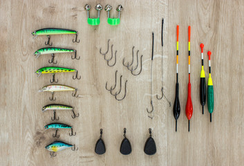 Fishing tackle - fishing float, lures, weights and bells on beautiful wooden background © yursavieno