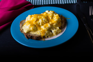 Scrambled eggs topped by grated cheese