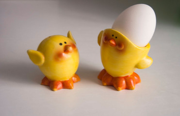 funny yellow chicks figures with an egg on a white background