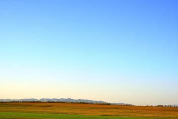 Fototapeta premium Rural area dawn landscape of fields and mountains near Saryozek, Almaty region