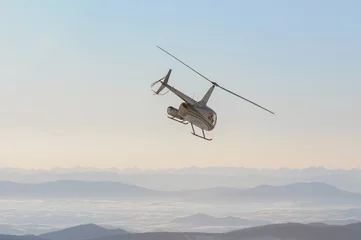 Photo sur Plexiglas hélicoptère Un hélicoptère s& 39 envolant vers les sommets des montagnes cachés dans le brouillard