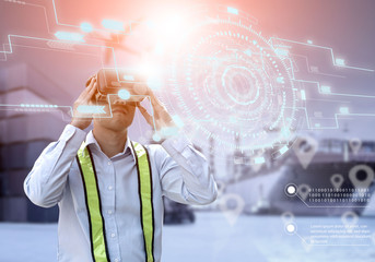 Virtual reality technology in industry 4.0.engineer working Wearing VR Headset look container cargo...