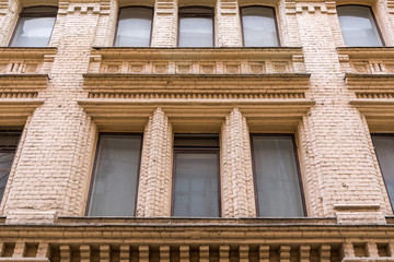 bottom view of the facade of a historic building with large windows