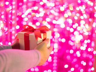 Woman holding gift box with bokeh background