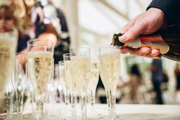 The waiter pours champagne to a party. glasses of champagne.