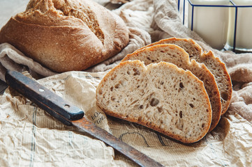 A beautiful loaf of sourdough bread from white wheat on a plate on a linen edge. Homemade pastries