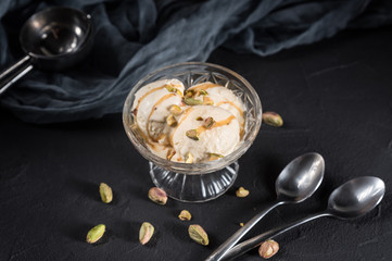 Homemade ice cream with caramel and nuts on dark background
