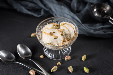 Homemade ice cream with caramel and nuts on dark background