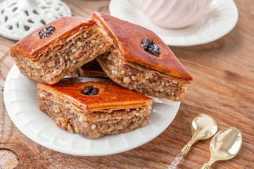 Traditional arabic dessert baklava with a cup of coffee, cashews, walnuts and cardamom on a wooden...