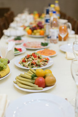 Laid table with vegetables, salads.