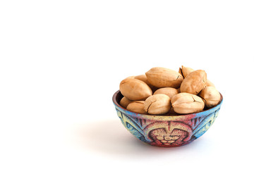 clay bowl with pecan nuts in shell on white background, copy space for text