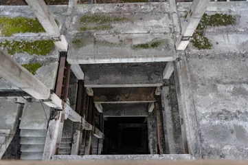 Foto op Plexiglas staircase in an unfinished building, abandoned, concrete floors, ruins, concrete elevator shaft © kurtov