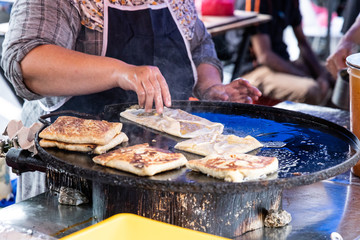 Seller preparing murtabak at street stall for iftar during Ramadan.
