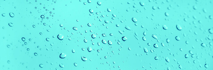 Water drops on glass panoramic blue background