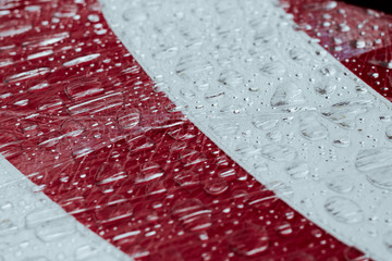 Large drops of water on a red-white surface