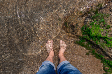 Feet in the water on the shore
