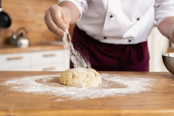 Making dough by male hands at bakery
