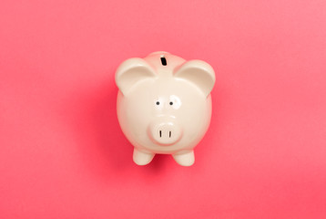 A piggy bank saving and investment theme on a pink paper background
