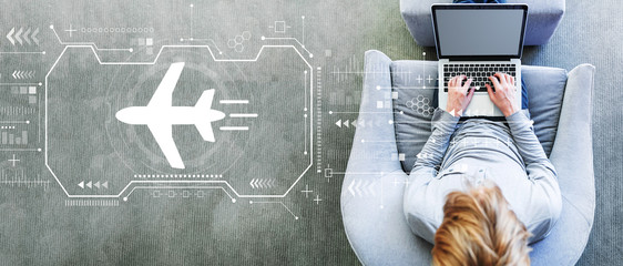 Airplane travel theme with man using a laptop in a modern gray chair © Tierney