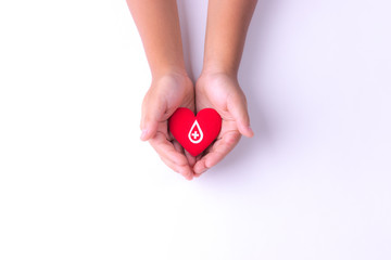 A child hands holding red heart for blood donation,world blood donor day. Copy space for advertisers.