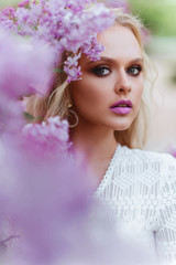 Beautiful woman enjoying lilac garden, young woman with flowers in green park. cheerful teenager walking outdoor. soft light style color.