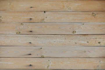 Wall of birch boards, painted with varnish. Boards are exactly trimmed and fitted to each other.